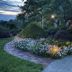 Annville Inn Bed and Breakfast in Annville garden path with flowers and lit cottage at dusk