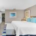 The Capitol Inn in Tallahassee guest room with twin beds, desk, wall-mounted TV and closet