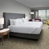 Crowne Plaza San Antonio Airport guest room with king bed, desk, TV and city-view window