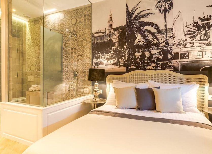 Procurator 7 Luxury Rooms in Split with a king bed, glass shower and palm mural wall