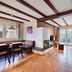 Nürburgring Ferienpark living area with fireplace, wood beams, dining nook and balcony doors in Nuerburg