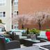 Residence Inn by Marriott Portsmouth outdoor patio with wicker seating, cushions, and flowering trees