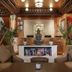 Hotel Tibet Kathmandu lobby with Buddha statue, seating area, and ornate wood-carved ceiling