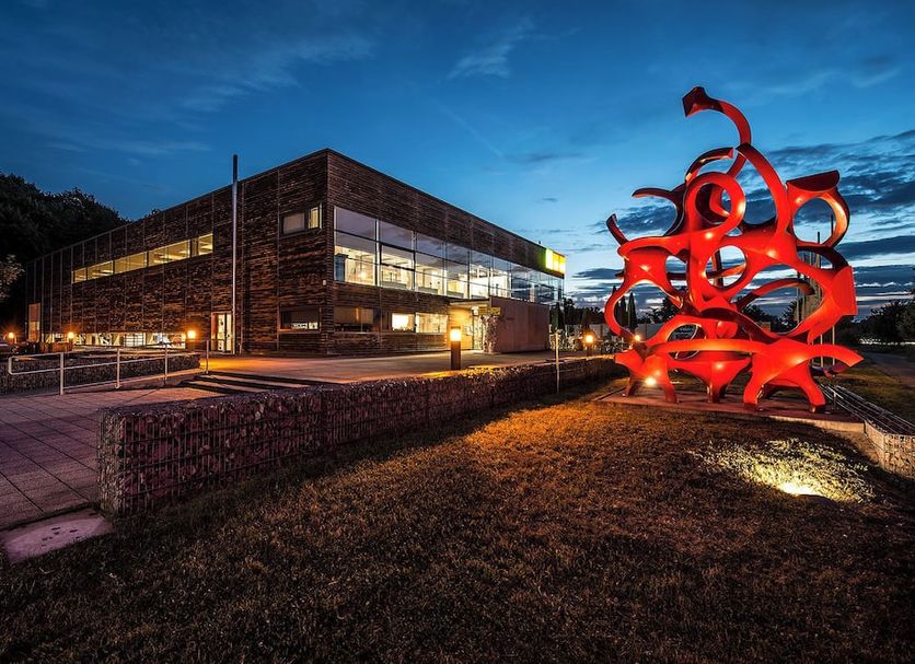 Parkhotel Luise in Bad Herrenalb exterior at dusk with illuminated modern building and red sculpture