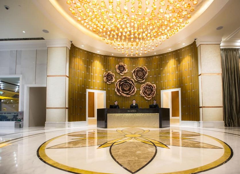 Winford Resort & Casino Manila lobby with gold chandelier, reception desk, and marble floor in Manila