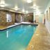 Indoor pool at Berlin Grande Hotel in Berlin with stone walls and lounge chairs