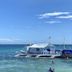 Magic Oceans Dive Resort in Anda with a white dive boat on clear tropical water by the shore