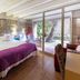 La Freixera, Solsona: stone-walled bedroom with glass doors opening to a tree-lined terrace