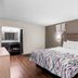 Red Roof Inn Richmond - Airport Sandston guest room with king bed, wall art, and wood flooring