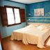 La Solana Montañesa in Comillas, blue guest room with double bed, wood shutters, and tiled floor