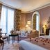Le Dokhan's, Paris Arc de Tiromphe hotel room with four-poster bed, sofa, and window seating in Paris