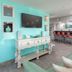 Surf & Sand Hotel in Pensacola Beach lounge with turquoise accent wall, TV, seating and bar stools