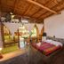 La Casa de Sebas in Máncora: rustic room with double bed, bunk bed, and patio dining area