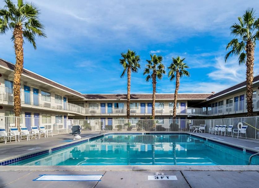 Motel 6 El Centro outdoor pool with palm trees and two-story motel rooms