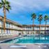 Motel 6 El Centro outdoor pool with palm trees and two-story motel rooms