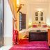 Dar Charkia Marrakech guest room with bed, colorful sofa, red rug and window seating