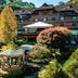 Hotel Casa da Montanha in Gramado with landscaped garden and gazebo in front of the chalet-style hotel.