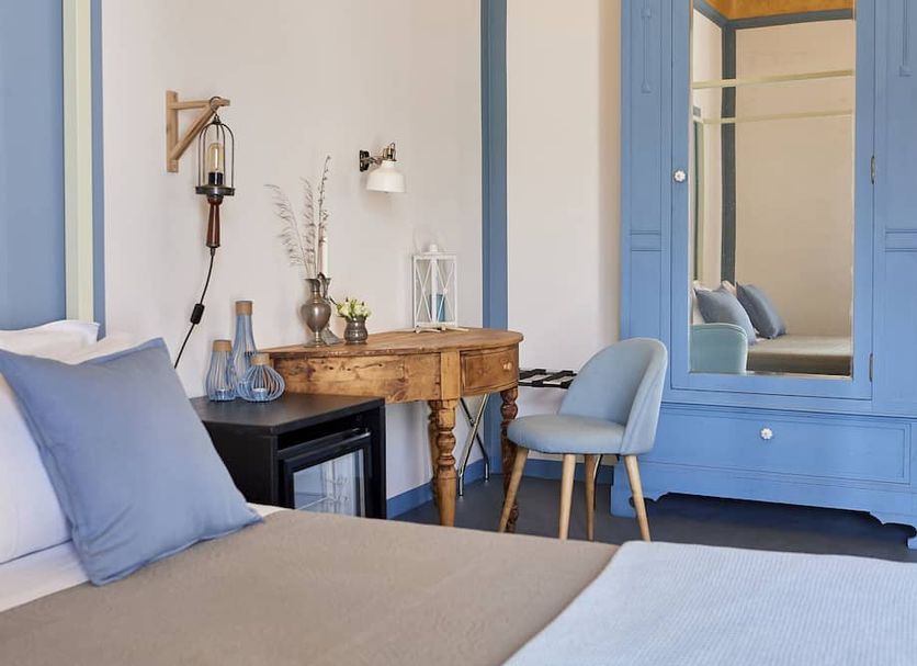 Cur ù B&B in Castellammare del Golfo: blue-accented room with bed, desk, chair, and mirrored wardrobe