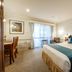 Twin Towers Inn in Artarmon guest room with king bed, desk, balcony doors and seating area
