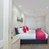 Pavilion Beachfront Apartments in Mount Maunganui bedroom with pink accent bedding and ceiling fan