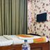 Om Mandakini Hotel Kathmandu room with twin beds, floral wallpaper, curtains, and wall-mounted TV