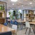Dorma Juan De Austria in Valladolid dining area with wooden tables, blue chairs, and indoor plants