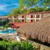 Hotel Plaza Palenque in Palenque with a pool, palm trees, and thatched-roof cabana by the courtyard