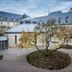 Kardinal Schulte Haus in Bergisch Gladbach courtyard with landscaped trees and historic building
