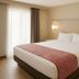 Floral Park Motor Lodge Queens guest room with king bed, bedside lamps, and window drapes