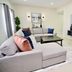 Rio Suites Tijuana living room with sectional sofa, coffee table, and wall-mounted TV