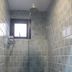 Vintage Inn Boutique Capsule @ Little India Singapore shower room with blue tiled walls and small window