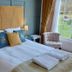 Laston House Ilfracombe guest room with king bed, tufted headboard, bedside lamps and window seat