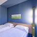 B&B Hotel Düsseldorf-Hilden twin room with blue accent wall and wall art in Hilden