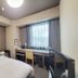 Hotel Route-Inn Court Chikuma-Koshoku guest room with bed, desk, and window view in Chikuma