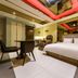 Daegu Innovalley in Daegu: modern guest room with king bed, desk, lounge chair and red-lit ceiling accents