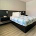 Motel 6 Costa Mesa guest room with bed, desk area, and large wall mirror