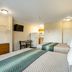 HomeTowne Studios by Red Roof Denver - Lakewood West guest room with two beds, TV, desk and kitchenette