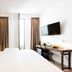 1st Floor Köln 2 hotel room in Cologne with bed, brick accent wall, desk, TV and balcony doors