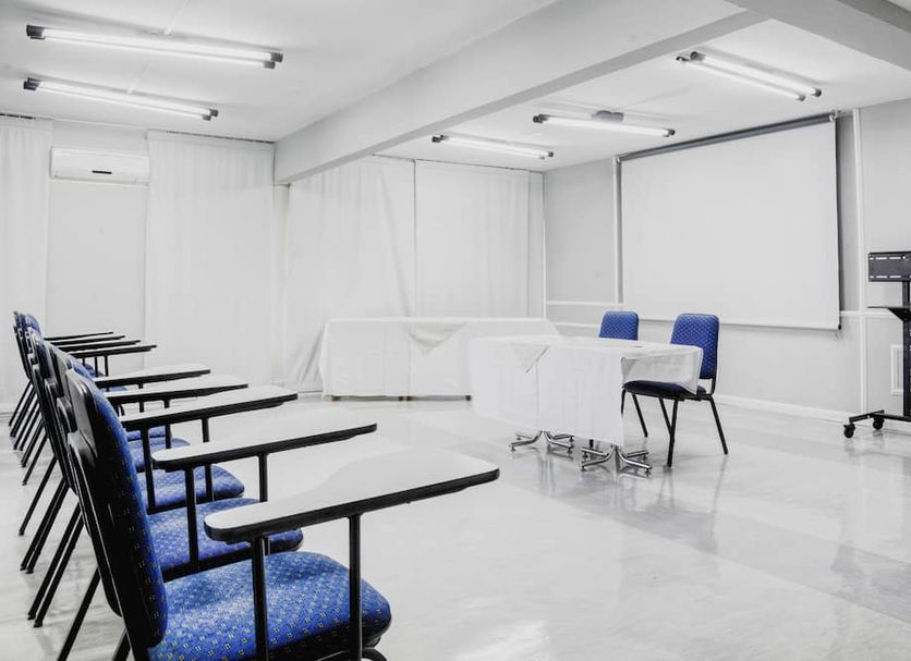 Hotel Nacional Inn Poços de Caldas meeting room with projector screen and conference chairs