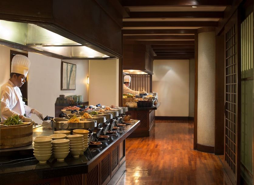 Hotel Bumi Surabaya buffet dining area in Surabaya with chefs serving dishes and polished wood floors