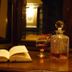 The Leather Bottle in Gravesend with open book, crystal decanter, wine glass and lit candle on a bar
