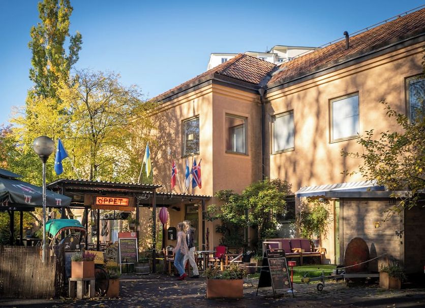 Reimersholme Hotel in Stockholm with outdoor café seating beside a peach-colored building and trees