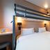 Kyriad Eco Lille Sud - Noyelles Godault room with bunk bed over twin beds and desk in Noyelles-Godault