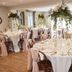 The Lawrence Burnley banquet room with round tables, white linens, and floral hanging centerpieces