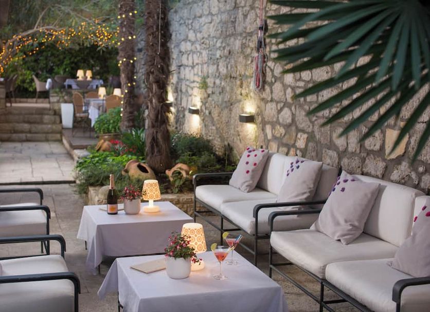 Hotel Angelo d'Oro in Rovinj: stone courtyard lounge with sofas, tables, and string lights