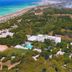 Aerial view of Hotel Club Astor in Ugento with pool, greenery, and coastline nearby