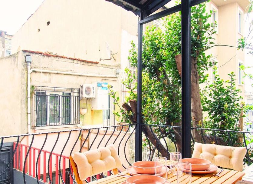 Taks-Inn Suites Istanbul balcony with outdoor dining table and leafy city view