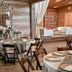 Hoffman Haus in Fredericksburg: rustic dining room with set tables and adjacent lounge seating