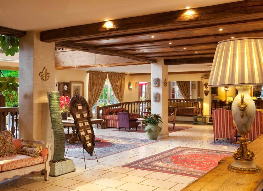 Le Manoir de Gressy in Gressy lobby with exposed beams, patterned rugs, and upholstered seating