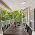 Sunset Cove Noosa balcony with dining table and tropical palm view in Noosaville